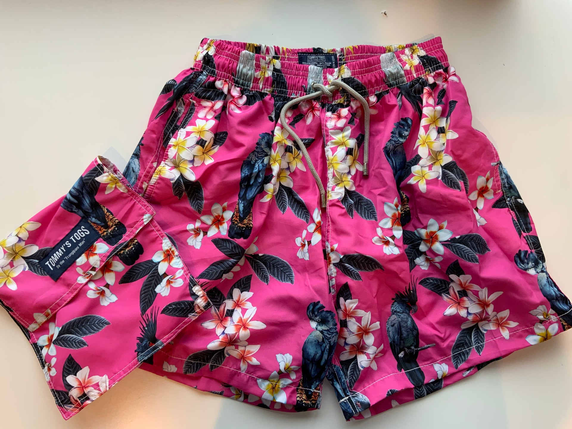Black cockatoo, frangipani, pink shorts – Tommy's Togs